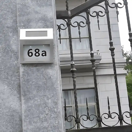 Solar LED house number light with illuminated address plaque.